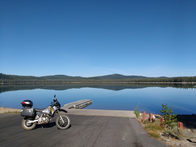 Motorcycle in front of lake with mountains